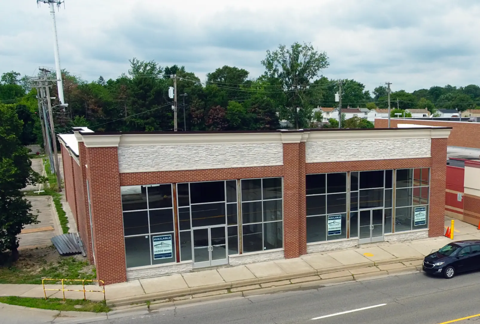 Original photograph of the selected brick building with two tall glass storefronts and separate entrances